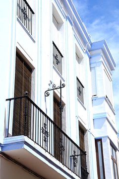 Traditional Spanish buildings with wrought iron balconies along Calle Angustias, Ayamonte, Spain.