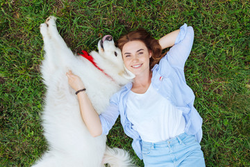Fluffy husky. Cute fluffy husky relaxing greatly while lying near his young appealing blonde-haired owner
