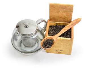 Glass teapot and tea leaves in wooden spoon and box