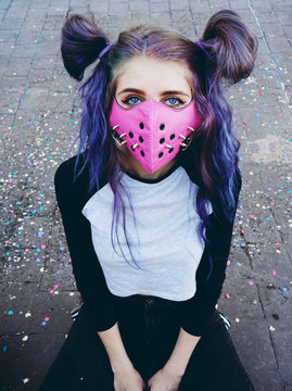 Chica joven con estilo urbano asiático y una máscara punk rosa con pinchos