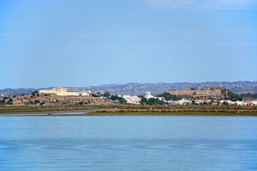 Fototapeta premium View across the River Guadiana towards the white town and its fort and castle, Castro Marim, Algarve, Portugal.