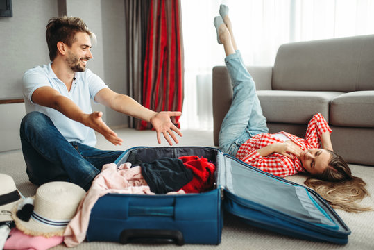 Young Couple Packing Their Suitcases For Vacation