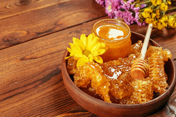 Obraz na płótnie Canvas Honey in jar with honey dipper on vintage wooden background