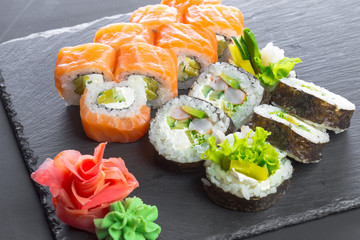 Japanese restaurant, sushi roll on black slate plate.