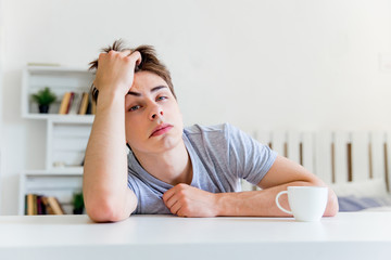 Young man drinking coffee and having breakfast