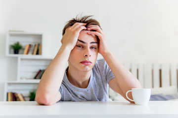 Young man drinking coffee and having breakfast