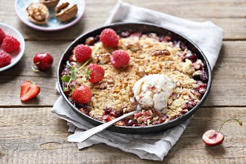 Oatmeal crumble with fresh berries and walnuts. Gluten free summer berries crisp. Selective focus