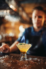 Bartender pours beverage into the glass with ice