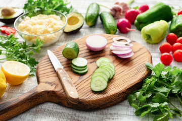 Fresh vegetables on cutting board. Cucumber, onion, pepper, parsley, radish avocado bulgur Preparing salad