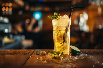 Fresh mojito in a glass and ice on bar counter