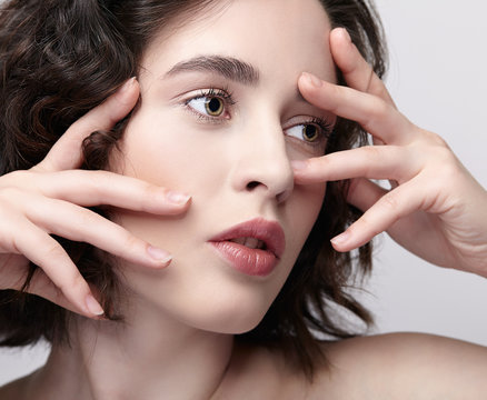 Closeup beauty portrait of young woman with hands near face