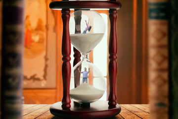 Man and woman inside hourglass, deadline concept