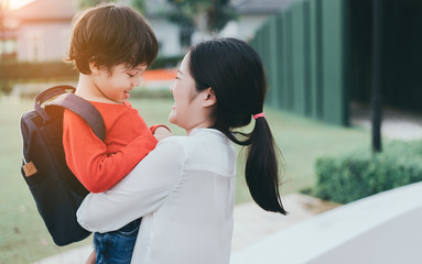 Mother get a son pupil from school after study school back to home village with satchel happy family lifestyle.