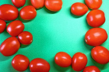 red tomatoes stacked in a frame on a green background