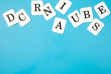 White cards of letters for little kids on the blue table. Time to learn. Education concept. Top view. Empty place for text.