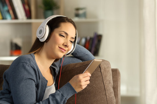 Relaxed woman listening to music on a couch