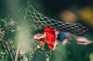 Selective focus of Cheerful woman playing ukulele in hammock