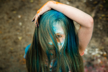 bright blonde girl whose hair in the paint Holi 