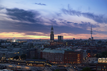 Fototapeta na wymiar Hamburg's landmarks at sunset - Ferries Wheel of Hamburg's Dom, St. Michael's church and television tower