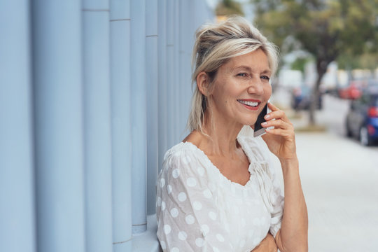 Cheerful mature woman talking on mobile phone