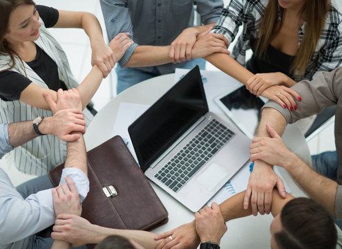 business team forms a circle of hands in the workplace