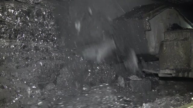 The coal combine works in a mine. Heavy mining equipment