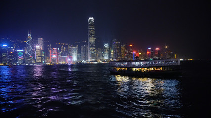 Obraz premium Hong Kong Island Skyline At Night With Star Ferry Entering Harbour
