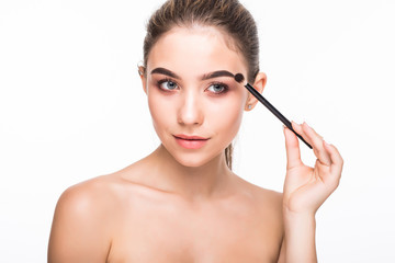 Beautiful woman using mascara of appealing brunette girl on white background