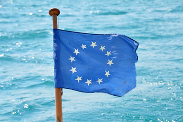 Close up flag of EU waving in wind over sea water