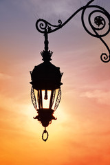 Fototapeta na wymiar Antique street lamp lantern over sunset sky