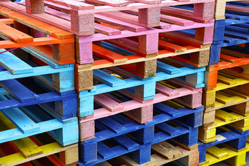 Stack of many multicolor painted wooden pallets