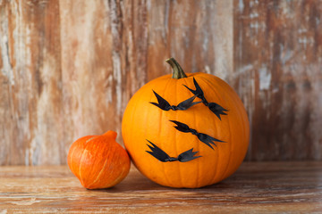 halloween and holidays concept - pumpkins with bats or party decorations
