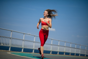 Young fitness woman running on the coast. The concept of a healthy lifestyle
