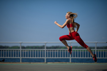 Young fitness woman running on the coast. The concept of a healthy lifestyle