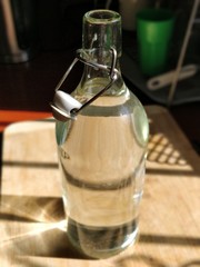 A bottle of water in the kitchen with sunlight reflections