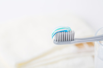Herbal toothpaste with a new toothbrush and a cup of water on the wooden table. Dental Care Concept.