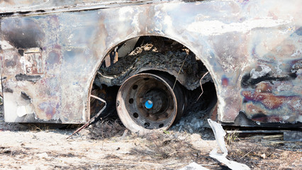 Burned bus at the side of the road, rim