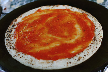 Pancake-pizza, an unusual preparation using dough for pancakes. Street food, cooking stages.