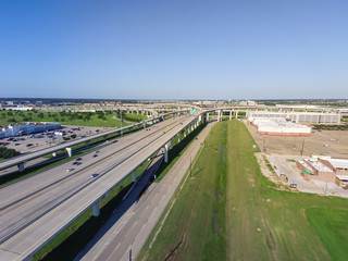 Top view Interstate 10 or Katy freeway with massive intersection, stack interchange, elevated road junction overpass in daytime with clear blue sky. Aerial metropolitan area of Katy, Texas, US