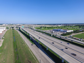 Top view Interstate 10 or Katy freeway with massive intersection, stack interchange, elevated road junction overpass in daytime with clear blue sky. Aerial metropolitan area of Katy, Texas, US - obrazy, fototapety, plakaty