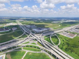 Horizontal aerial view Interstate 10 or Katy freeway massive intersection, stack interchange, elevated road junction overpass in daytime cloud blue sky. Aerial metropolitan area of Katy, Texas, USA - obrazy, fototapety, plakaty