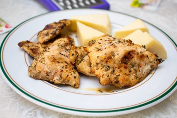 Meat and cheese lie on a white plate with a green edging