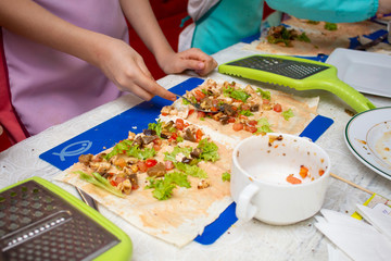 the child's hands are prepared to eat from vegetables and meat