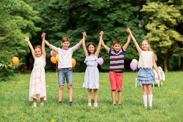 Naklejka na ściany i meble holidays, childhood and celebration concept - happy kids having fun on birthday party at summer park