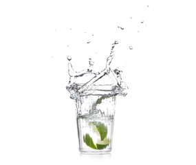 Glass with splashing water and sliced citrus fruit on white background