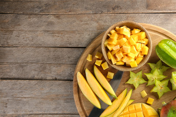 Composition with fresh mango on wooden background