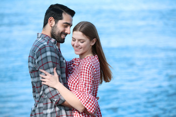 Happy young couple near river on spring day