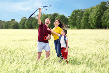 Fototapeta premium Happy family flying kite in the field
