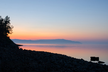 Stone beach and lake on a dawn. Paysage.