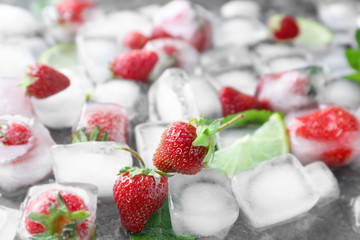Ice cubes with strawberries on table